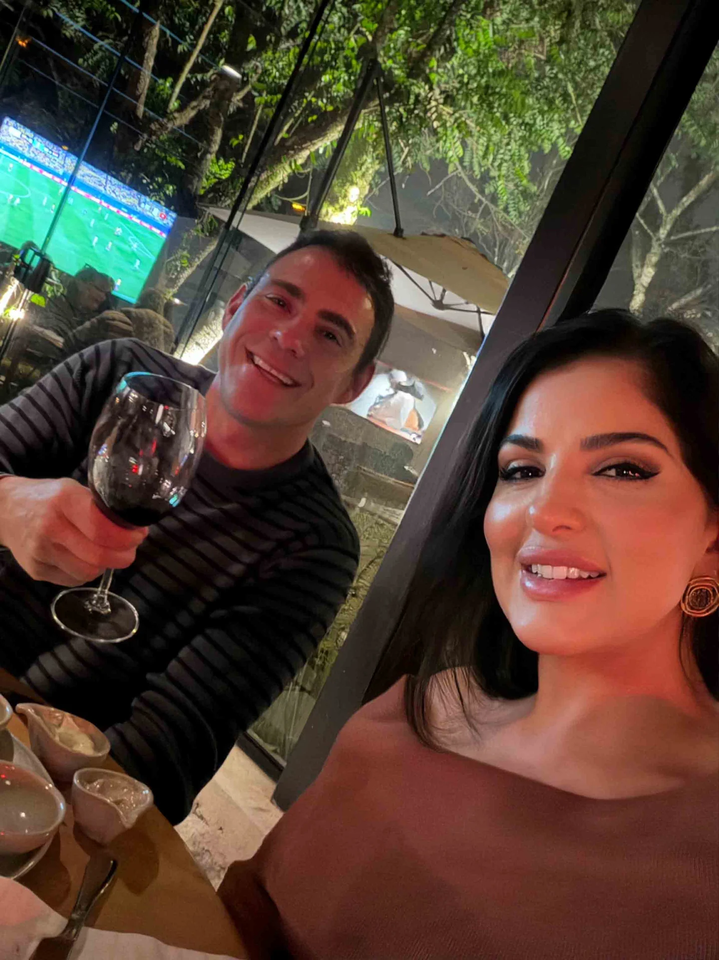 Anfitriões recebendo visitantes com café em um ambiente cercado pela natureza.