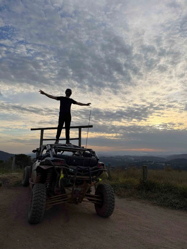Participante celebrando sobre um UTV com vista para a serra.