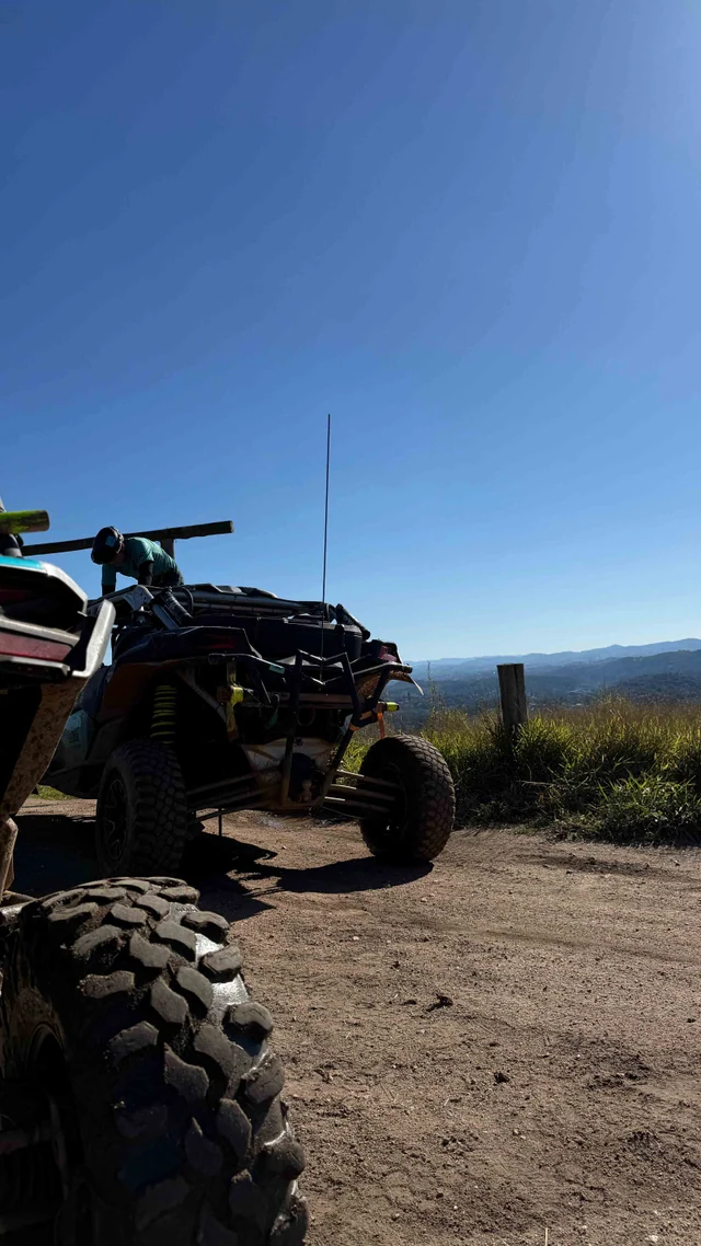 UTV parado em mirante com céu azul e vista ampla.